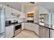 Stylish kitchen featuring stainless steel appliances, white cabinets, and a pass-through window at 304 Caloosa Palms Ct, Sun City Center, FL 33573
