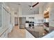 Bright kitchen featuring stainless steel appliances, white cabinets, and stone countertops at 304 Caloosa Palms Ct, Sun City Center, FL 33573
