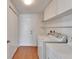 Convenient laundry room with a washing machine, dryer, cabinets, and laminate wood flooring at 304 Caloosa Palms Ct, Sun City Center, FL 33573