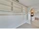 Open shelving lining a spacious living area, complemented by tile flooring and access to other rooms at 304 Caloosa Palms Ct, Sun City Center, FL 33573