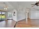 Spacious living room with wood-look flooring, vaulted ceilings, and seamless access to the lanai at 304 Caloosa Palms Ct, Sun City Center, FL 33573