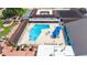 Aerial view of a community pool area with a hot tub, tables with umbrellas, and lounge chairs at 304 Caloosa Palms Ct, Sun City Center, FL 33573