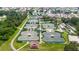 Aerial shot of a tennis complex offering several courts, green landscaping, and a view of a nearby neighborhood at 304 Caloosa Palms Ct, Sun City Center, FL 33573