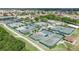 Expansive aerial view of a community tennis court complex with multiple courts, landscaping, and trees at 304 Caloosa Palms Ct, Sun City Center, FL 33573