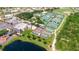 Aerial view of a tennis court complex with multiple courts, landscaping, and parking at 304 Caloosa Palms Ct, Sun City Center, FL 33573