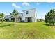 Spacious backyard featuring lush green grass and access to the home through glass sliding doors at 308 Mangrove Shade Cir, Apollo Beach, FL 33572