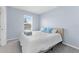 Light and airy bedroom featuring a queen bed, a window and soft blue accent walls at 308 Mangrove Shade Cir, Apollo Beach, FL 33572