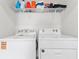 Washer and dryer in laundry room, complete with overhead shelving and storage space at 308 Mangrove Shade Cir, Apollo Beach, FL 33572