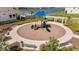 Aerial shot of a well-maintained playground with a blue canopy, benches, and surrounding landscaped area near a lake at 308 Mangrove Shade Cir, Apollo Beach, FL 33572