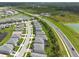 Aerial view of a residential area featuring modern homes and a picturesque pond at 3144 Mountain Spruce Ter, Wesley Chapel, FL 33543