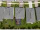 A view of multiple homes with a screened-in patio and well-kept yards at 3144 Mountain Spruce Ter, Wesley Chapel, FL 33543
