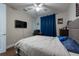 A teen bedroom with hardwood floors, a desk, a queen-size bed, and blue curtains at 3144 Mountain Spruce Ter, Wesley Chapel, FL 33543