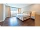 A spacious bedroom featuring wood floors, a queen-size bed, natural light, and neutral decor at 3144 Mountain Spruce Ter, Wesley Chapel, FL 33543