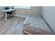 Spare bedroom featuring a simple bed on the floor, desk, chair, and wood-look flooring at 3144 Mountain Spruce Ter, Wesley Chapel, FL 33543