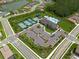 Aerial view of community pool, tennis courts, parking, and landscaping at 3144 Mountain Spruce Ter, Wesley Chapel, FL 33543