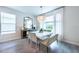 Modern dining room with a white table, contemporary chandelier, and large windows for natural light at 3144 Mountain Spruce Ter, Wesley Chapel, FL 33543