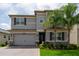 Charming two-story home with a well-manicured lawn, palm trees, and gray trim at 3144 Mountain Spruce Ter, Wesley Chapel, FL 33543