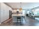 Open concept kitchen with white cabinetry, stainless steel appliances, an island with barstools, and dining area at 3144 Mountain Spruce Ter, Wesley Chapel, FL 33543