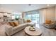 Bright and airy living room with a large sectional sofa, sliding glass doors, and an adjacent modern kitchen at 3144 Mountain Spruce Ter, Wesley Chapel, FL 33543