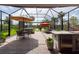 Screened-in patio with multiple seating areas, including a hot tub and outdoor kitchen at 3144 Mountain Spruce Ter, Wesley Chapel, FL 33543