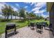 Spacious backyard with a stone paver patio, barbecue grill, and comfortable seating for outdoor entertaining at 3318 Woodland Brook Way, Wesley Chapel, FL 33543
