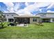 Backyard features patio, screened in porch and outdoor kitchen area for relaxation and entertaining at 3318 Woodland Brook Way, Wesley Chapel, FL 33543