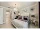 Main bedroom features a crystal chandelier, white headboard, tile floors, and neutral decor at 3318 Woodland Brook Way, Wesley Chapel, FL 33543