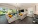 Bright living room featuring sliding glass doors, hardwood floors, and a modern light fixture at 3318 Woodland Brook Way, Wesley Chapel, FL 33543