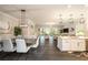 Open concept living space with view of dining, kitchen, and living room featuring hardwood floors and modern light fixtures at 3318 Woodland Brook Way, Wesley Chapel, FL 33543