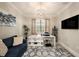 Inviting home office with a cozy blue sofa, a modern desk, and natural light from the window at 3318 Woodland Brook Way, Wesley Chapel, FL 33543