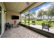 Screened-in patio with a ceiling fan, outdoor furniture, a mounted TV, and a view of the backyard at 3318 Woodland Brook Way, Wesley Chapel, FL 33543