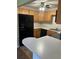 Kitchen featuring wood cabinets, black appliances and a breakfast bar, perfect for meal prep and casual dining at 337 S Mcmullen Booth Rd # 157, Clearwater, FL 33759