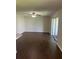 Spacious living room featuring dark, wood-look tile flooring and a ceiling fan with sliding door access to the outdoors at 337 S Mcmullen Booth Rd # 157, Clearwater, FL 33759