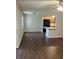 Open-concept living room leading to kitchen, complete with wood-look tile flooring and natural light from a window at 337 S Mcmullen Booth Rd # 157, Clearwater, FL 33759