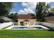 Backyard with pool, white fence, and yellow home at 346 Gray Oak Dr, Tarpon Springs, FL 34689