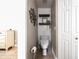 Half bathroom with shiplap accent wall, wooden shelves, and modern toilet at 346 Gray Oak Dr, Tarpon Springs, FL 34689