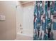 Clean bathroom with a white tiled bathtub, shower head, and leafy patterned shower curtain at 346 Gray Oak Dr, Tarpon Springs, FL 34689