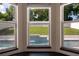 View of backyard pool through bay window with beautiful green landscaping at 346 Gray Oak Dr, Tarpon Springs, FL 34689
