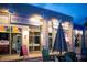 Outdoor view of the stores at Wine at the Docks with outdoor seating and lighted signs at 346 Gray Oak Dr, Tarpon Springs, FL 34689