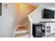 Staircase with wooden steps, patterned runner, white railing, beverage fridge, and media center with a television at 346 Gray Oak Dr, Tarpon Springs, FL 34689