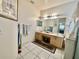 Bright bathroom features a large mirror above the sink, neutral walls and tile floors at 3501 Pine Top Dr, Valrico, FL 33594