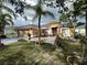 Charming single-story home featuring a well-manicured lawn, complemented by lush tropical landscaping and a two car garage at 3501 Pine Top Dr, Valrico, FL 33594