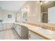 Bright bathroom featuring dual sinks, tile backsplash, white cabinetry, and a shower reflected in the mirror at 36731 Tara Ave, Zephyrhills, FL 33542