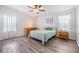 Well-lit bedroom featuring a bed, dresser, ceiling fan, and plank flooring at 36731 Tara Ave, Zephyrhills, FL 33542