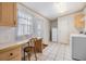 Bright laundry room with white appliances, tile floor, and convenient desk area at 36731 Tara Ave, Zephyrhills, FL 33542
