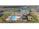 Aerial view showcasing community pool, clubhouse, playground, surrounding ponds and residential houses at 37820 Beacon Brick Dr, Zephyrhills, FL 33540