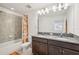 Bathroom with a double granite vanity, shower with patterned curtain and lots of mirror space at 37820 Beacon Brick Dr, Zephyrhills, FL 33540