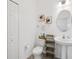Stylish powder room with a pedestal sink, decorative art, and white walls with lots of light at 37820 Beacon Brick Dr, Zephyrhills, FL 33540