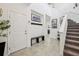 Inviting foyer featuring a staircase, coat rack, bench, and neutral tile flooring at 37820 Beacon Brick Dr, Zephyrhills, FL 33540