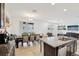 Bright, open-concept kitchen with stainless appliances, granite island, and view of dining and living spaces at 37820 Beacon Brick Dr, Zephyrhills, FL 33540
